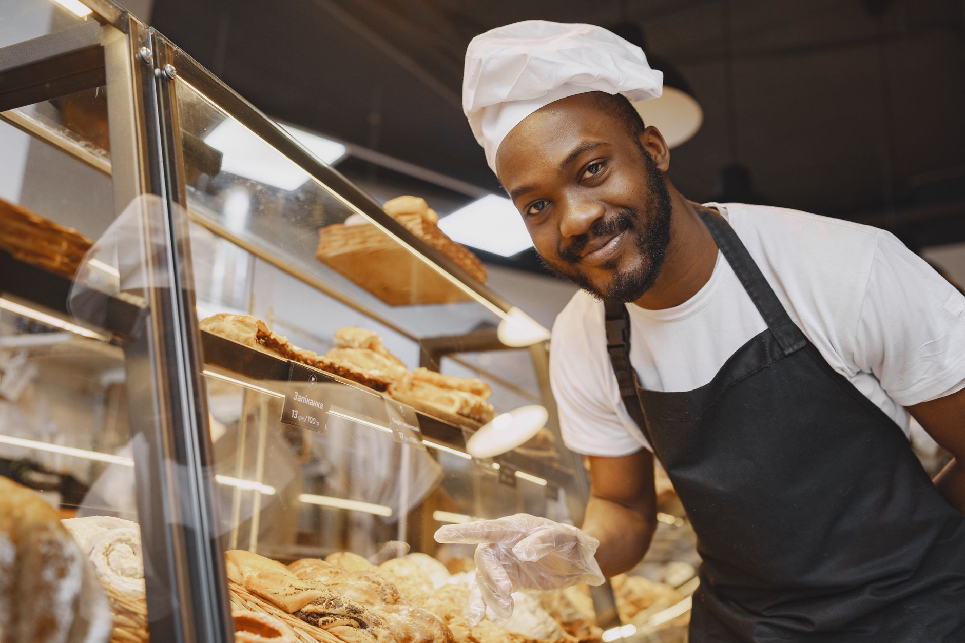 A baker standing behind the counter of a small bakery