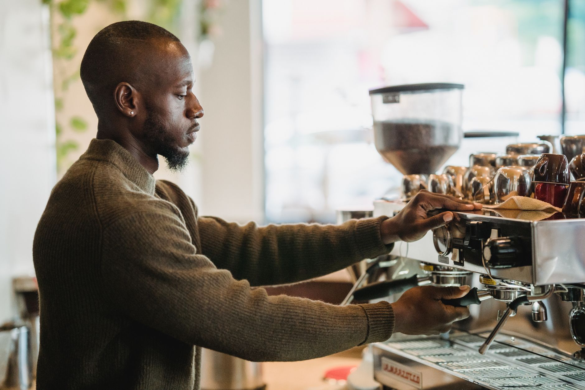 A barista pulling espresso behind a coffee shop counter