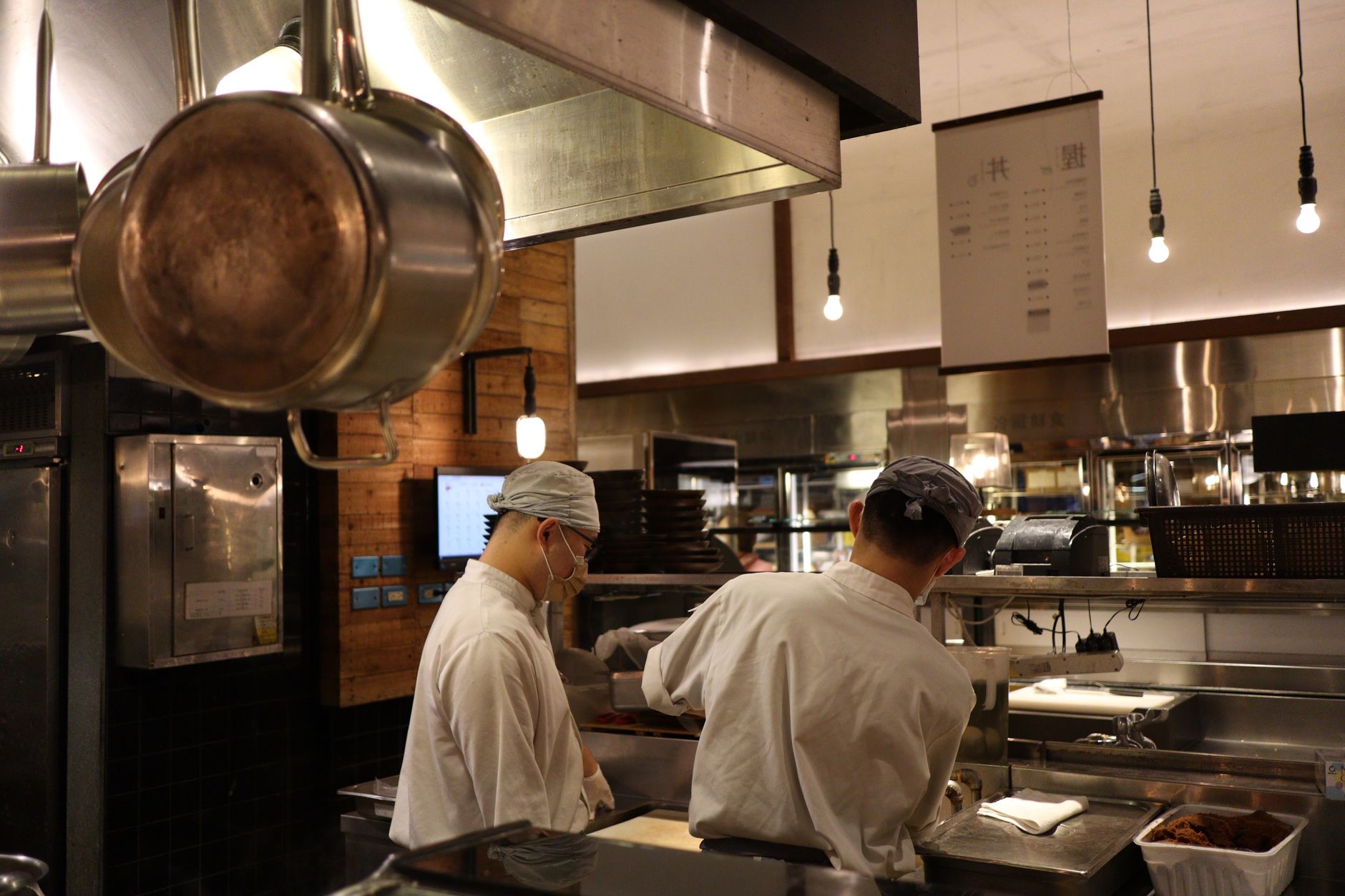 A chef plating food in a busy restaurant kitchen
