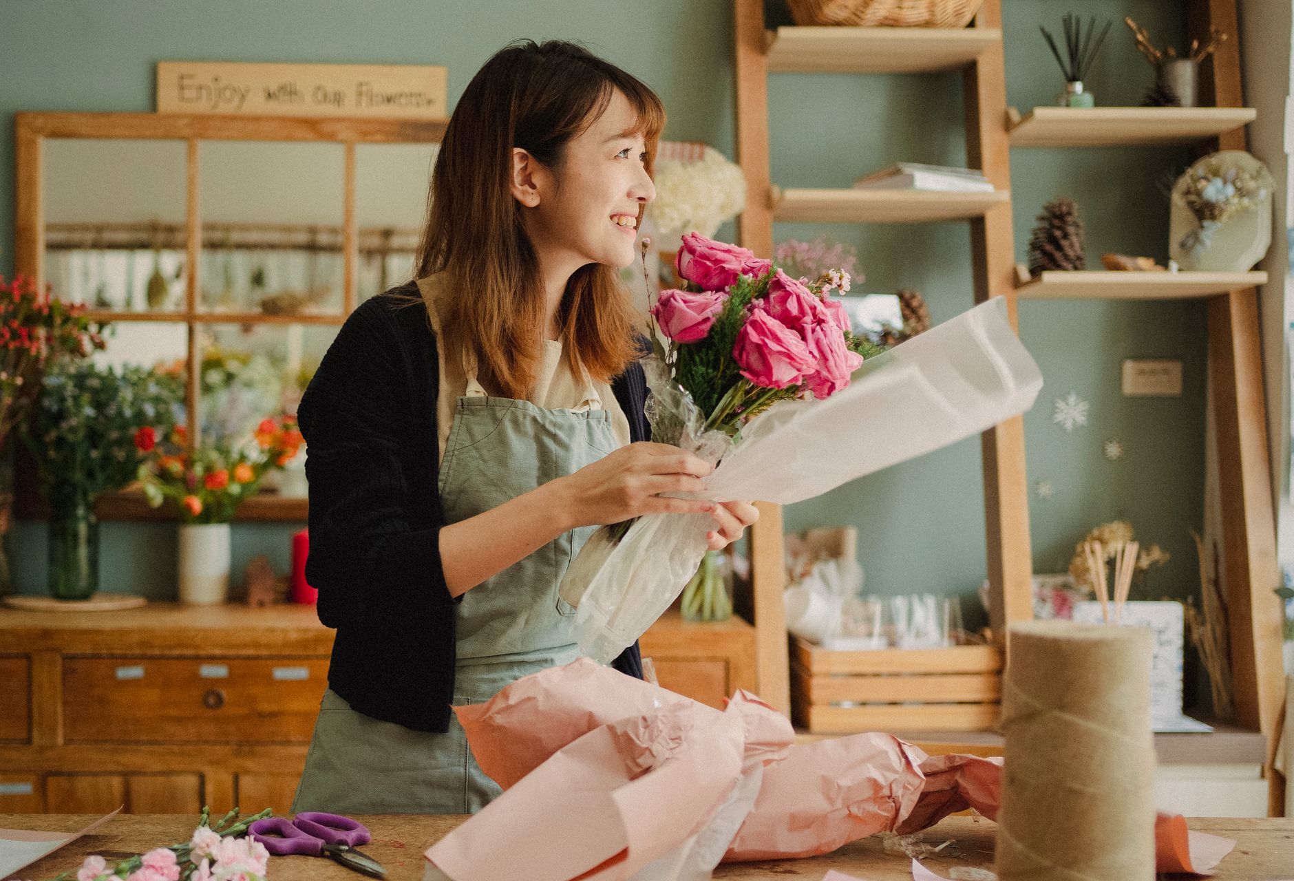 A florist arranging stems in her shop