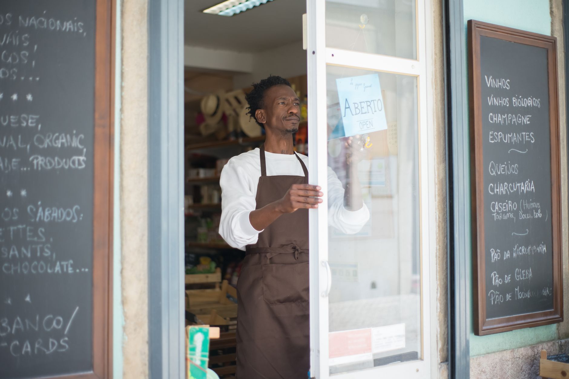 A shop owner standing in the doorway of their storefront